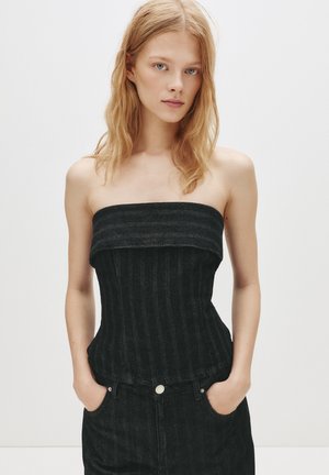 Top din denim negru fără bretele, cu o textură ribbed verticală și un design ajustat. Prezintă un decolteu drept și se află deasupra taliei.