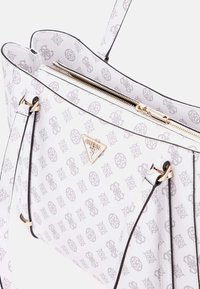 Borsa bianca texturizzata con motivo logo grigio, accessori in oro e profili neri. Presenta doppie spalline e chiusura superiore con zip.
