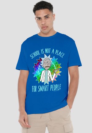 Young man wearing blue T-shirt with cartoon scientist and text "School is not a place for smart people" on colorful background.