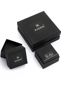 Three black Kuzzoï branded square boxes, one open and the other two closed, showing logo and recycled paper label.