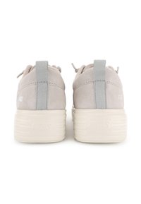 Baskets en suède gris clair avec une semelle blanche texturée et surélevée. Les caractéristiques incluent une languette grise et un logo minimaliste au niveau du talon.