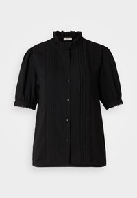 Blusa negra con un alto cuello con volantes, mangas cortas abullonadas y cierre de botones. Presenta plisados verticales y acentos de encaje.