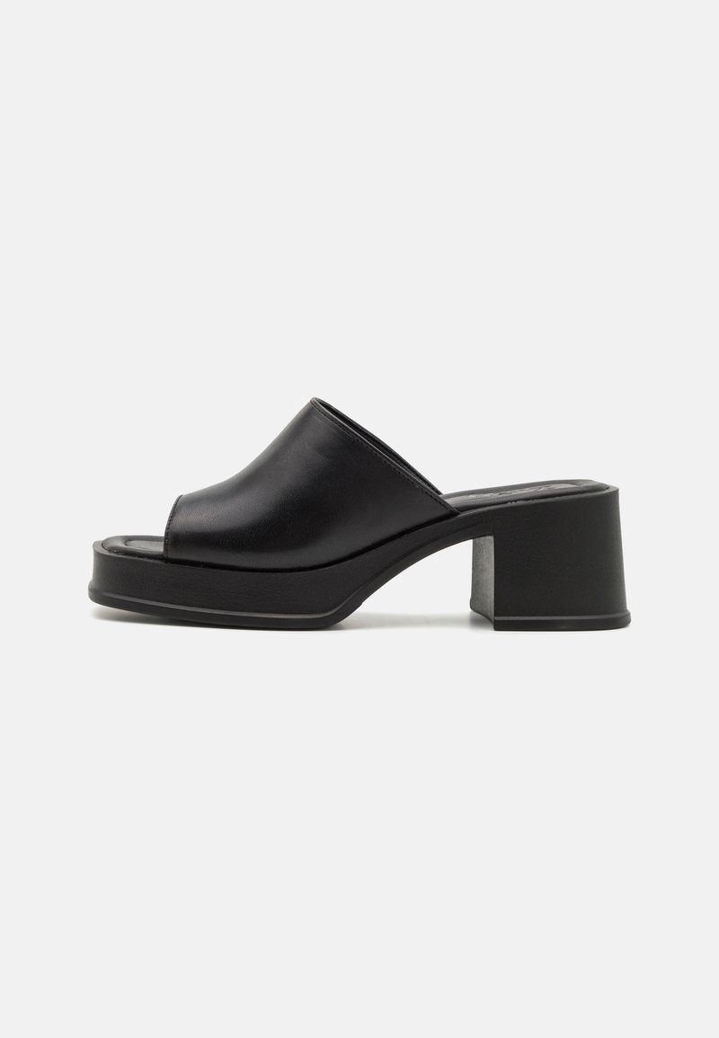 Black leather platform mules with a rounded open toe, low block heel, and smooth texture. Minimalist design with sleek lines.