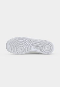 Λευκή σόλα παπουτσιού Nike με κυκλικά μοτίβα πέλματος και λογότυπο Nike στο κέντρο σε απλό λευκό φόντο.