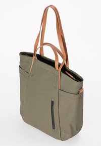 Olijfgroene tote bag met twee tan leren handvatten, voorzakken en een met rits afsluitbaar zijvak. Soepele textuur en minimalistisch ontwerp.