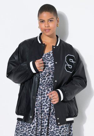 Black varsity jacket with white stripes on the collar and cuffs, featuring an embroidered letter "S" on the chest. Smooth texture.