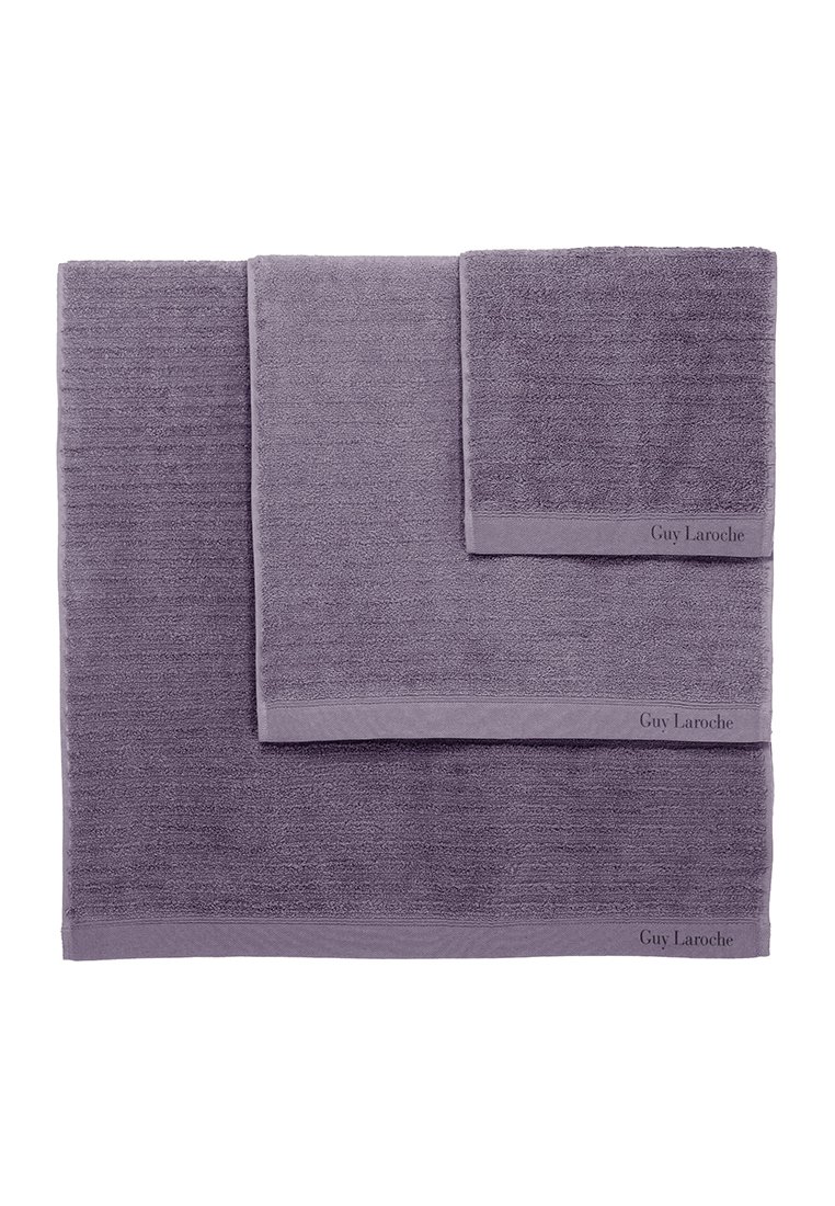 Trzy lawendowe ręczniki o różnych rozmiarach, wykonane z miękkiej bawełny. Każdy ma subtelną fakturę i haft "Guy Laroche" na krawędzi.