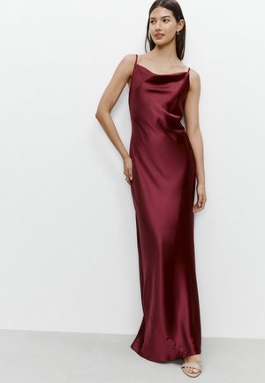 Burgundy satin liukupuku, jossa on spagettiolkain, lattiaan ulottuva malli, sileä pinta ja kevyt laskos kaula-aukossa ja helmassa.