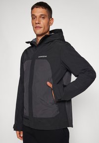 Waterproof black jacket with grey accents, featuring a hood, zippered pockets, and adjustable cuffs for a secure fit.