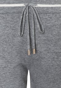 Graue Jogginghosen mit einem Kordelzugbund und goldfarbenen Metallenden sowie einem weißen Streifendetail in der Nähe des Bunds, gefertigt aus weichem Stoff.