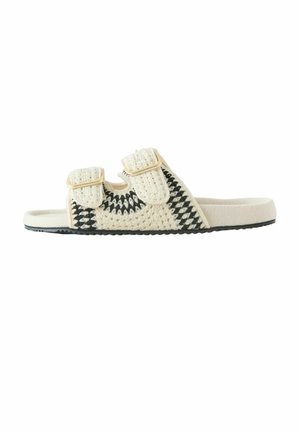 Béžovo-čierna háčkovaná šľapka s dvoma nastaviteľnými remienkami so sponou a plochou podrážkou.