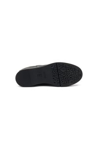 Suela de zapato de material de goma negra, texturizada con un patrón geométrico para mayor tracción. Diseño de punta redondeada y tacón plano.