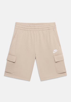 Beige Nike-shorts med elastisk taljebånd, to sidelommer og to cargolommer, med en hvid Nike-logo på højre ben.