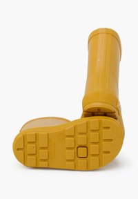 Botte de pluie en caoutchouc jaune avec une semelle texturée, un bout arrondi et un tige légèrement striée. Équipée d'une sangle ajustable près de la cheville.