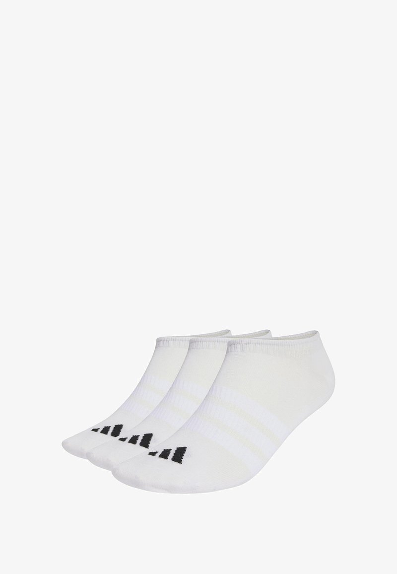 Tres pares de calcetines blancos hasta el tobillo con acentos de logo triangular negro en las puntas, dispuestos uno al lado del otro sobre un fondo blanco.