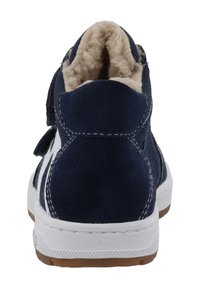 Blaue Wildlederschuhe im High-Top-Stil mit einer weißen Gummisohle, weichem beigefarbenem Innenfutter und einem Klettverschluss an der Seite. Kontrastnähte sind sichtbar.
