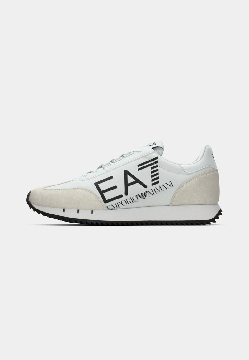 Hvid sneaker med ruskindsdetaljer, med sort "EA7 EMPORIO ARMANI"-branding, tekstureret gummisål og et strømlinet, atletisk design.