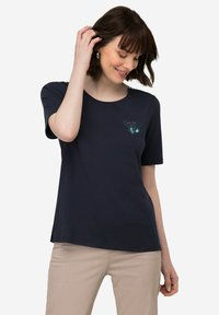 Navyblauwe t-shirt met korte mouwen van zachte katoen, met een borstafbeelding met ingewikkelde details in lichte en donkere kleuren. Ronde halslijn.