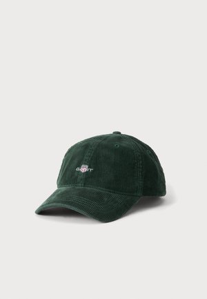 Casquette de baseball en velours côtelé vert foncé avec une visière courbée et un petit logo brodé blanc et rouge à l'avant.