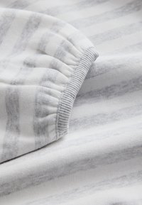 Material textil din bumbac cu o textură moale, prezintă dungi orizontale gri deschis pe un fundal alb și are o margine adunată și o bordură cu nervuri.