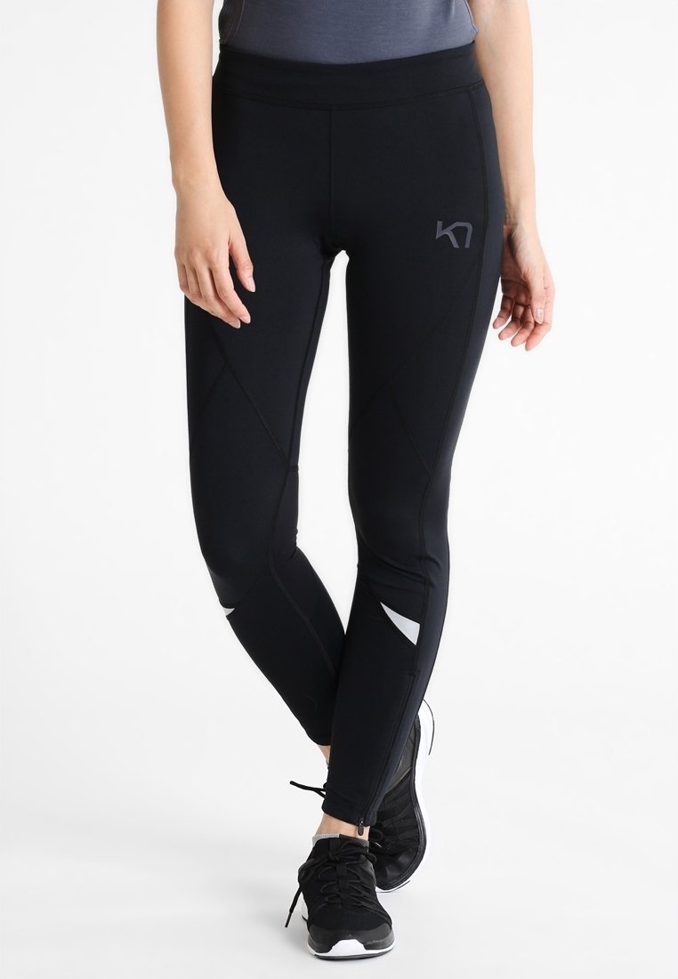 Černé sportovní legíny s přiléhavým střihem, s texturovanými švy a reflexními detaily na dolních nohavicích.