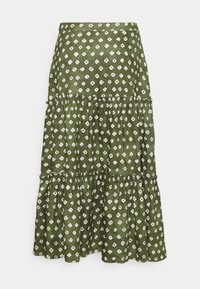 Grön, lager-på-lager kjol i lätt tyg, med ett vitt diamantmönster, och en draperad midja samt volangkant.