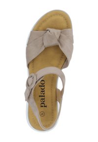 Sandalia de ante beige con detalle de tira anudada, plantilla acolchada dorada, suela de goma blanca y acento de hebilla metálica circular.