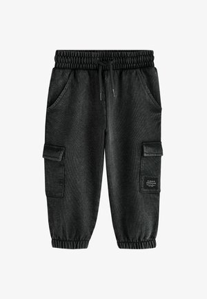 Sorte cargobukser med elastisk linning og manchetter, snøre foran, sidelommer og klaplommer på begge ben.