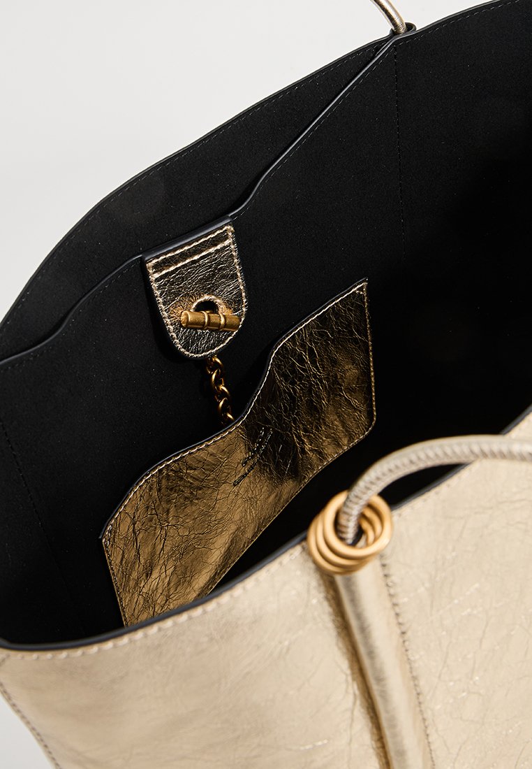 Goldfarbene Metallic-Handtasche mit schwarzem Innenfutter. Verfügt über eine goldene Tasche und Kettendetails. Glatte Textur mit leichtem Glanz.
