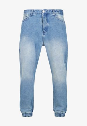Heledan sinised denim jogger-püksid elastse vöökoha ja mansettidega, millel on pleekinud pesu ja traditsiooniline viietasku disain.