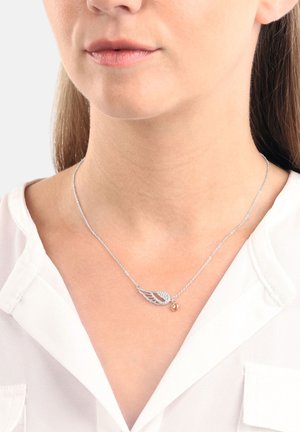 Silberne Halskette mit Flügeldesign, verziert mit Strasssteinen und einem kleinen herzförmigen Anhänger aus Roségold. Die Kette hat ein zartes, strukturiertes Aussehen.