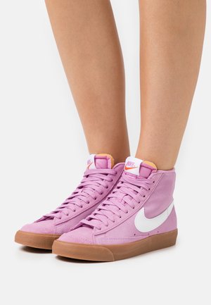Rosa Wildleder-Hochschnitt-Sneaker mit weißem Logo, hellbrauner Gummisohle und pinken Akzenten an der Zunge. Verfügt über ein klassisches Schnürdesign.