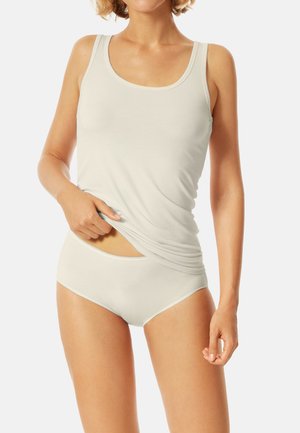 Helles beiges Tanktop und passende Shorts, aus glattem Baumwollmaterial. Das Tanktop hat breite Träger und ein elastisches, figurbetontes Design.