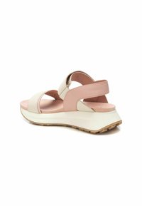 Sandalia ligera con correas sintéticas en crema y rosa, plantilla acolchada y suela de goma texturizada para una mejor adherencia.