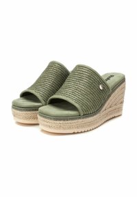 Sandalias verdes de cuña con parte superior trenzada, diseño de punta abierta y suela estilo esparto texturizada. Cuenta con un pequeño acento metálico.