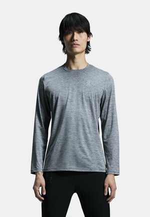 T-shirt à manches longues et col rond en tissu gris chiné. Présente un logo sur la poitrine et une texture lisse et légère.
