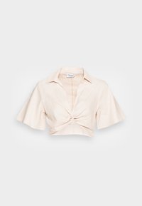 Camisa cropped em bege claro com colarinho, mangas curtas e largas, e um detalhe de nó na frente. Tecido suave e leve com uma textura sutil.