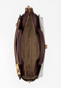 Rakennettu käsilaukku, joka on valmistettu burgundinpunaisesta keinonahasta, kullalla varustettuna, kaksinkertaisilla vetoketjuilla ja beigevuorilla, joissa on brändin nimi kauniisti kuvitettuna.