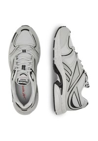 Szare buty sportowe z siateczki i materiałów syntetycznych, z czarnymi akcentami, teksturowaną podeszwą i sznurowanym zapięciem.