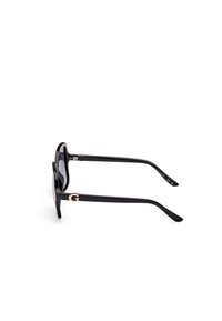Black sunglasses with a glossy finish, rounded lenses, and gold accents on the temples, featuring a prominent "G" logo detail.