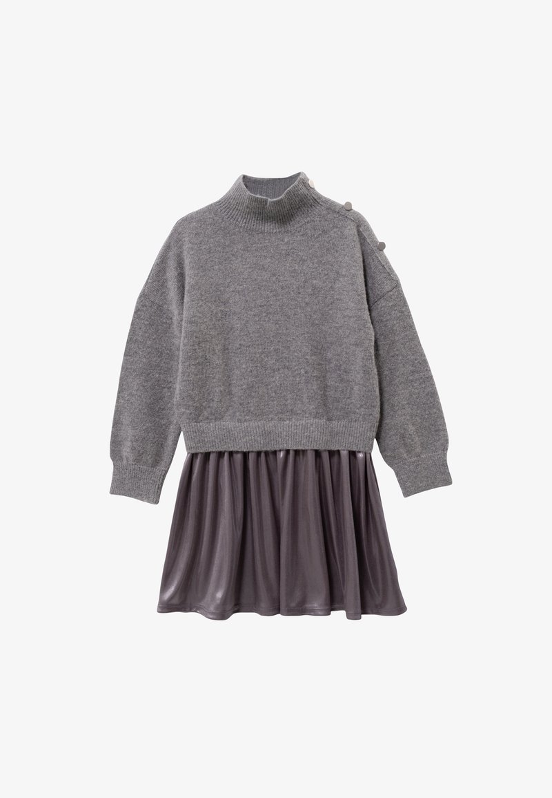 Szary dziany sweter z wysokim kołnierzem i trzema dekoracyjnymi guzikami, w zestawieniu z lekko opadającą ciemnoszarą satynową spódnicą. Długie rękawy.