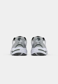 Running shoes with a gray and white mesh upper, black accents, padded collar, and cushioned sole. Features a textured rubber outsole.