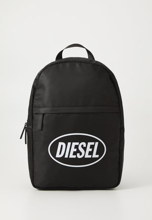 Fekete nylon hátizsák lekerekített formával, az elején egy nagy fehér "DIESEL" logóval, tetején fogantyúval és egy elülső cipzáras zseb részlettel.