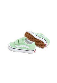 Roheline sametist madalate tossudega, millel on valged aktsendid, Velcro-rihmad ja tekstureeritud kummine paun. Klassikaline Vans'i disain.