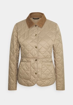 Veste matelassée beige avec col en velours côtelé marron, boutons pression sur le devant, deux poches avant et taille cintrée.
