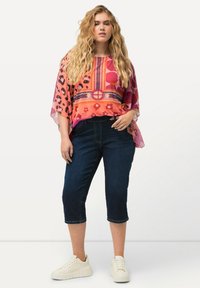 Monivärinen kukkakuosiseksi ja leopardikuosiseksi yläosa, jossa on valuvat hihat, yhdistettynä tummiin farkkukaprihousuihin ja valkoisiin tennareihin. Silkkinen, pehmeä kangas.