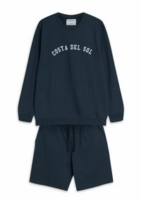 Granatowy zestaw bluz i krótkich spodenek. Bluza ma nadruk "COSTA DEL SOL" w kolorze białym. Wykonana z bawełnianego materiału, luźny krój, elastyczny pas.