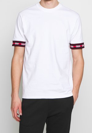 Weißes Baumwoll-T-Shirt mit kurzen Ärmeln, das an den Bündchen schwarze und rote Streifenakzente aufweist und ein Logomuster zeigt.