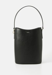 Sac seau en cuir noir avec un design courbé et minimaliste, doté d'une seule poignée et d'un logo "BOSS" en relief à l'avant.