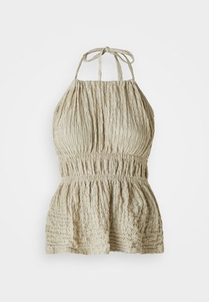 Light beige halter top with textured fabric, featuring a gathered bodice and elastic waist, styled for a casual, relaxed look.